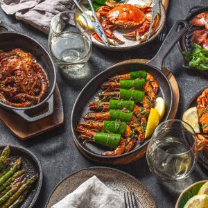 Assortment of grilled seafood on black background. Crabs octopus squids and prawns on drone pans