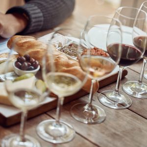 Wine tasting, cheese board and winery restaurant with alcohol and glass for customer. Eating, drink and person with rich wines and food pairing in a fine dining