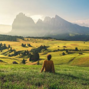 Young man relaxing on alpine meadow in Dolomites Alp mountains